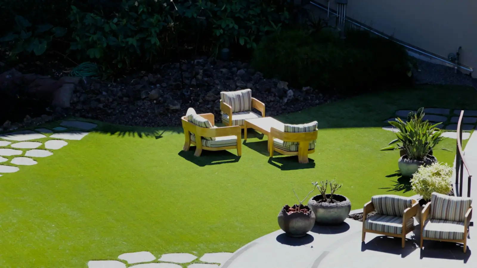 Terraza con césped artificial y muebles de exterior